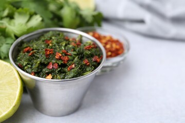 Tasty sauce with cilantro and other ingredients on light table, closeup. Space for text
