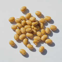 Pile of tan colored beans on a white surface with shadows.