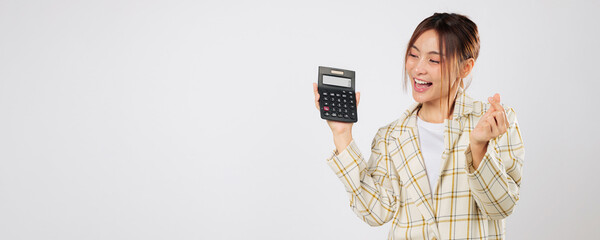 Excited woman holding calculator and forming finger heart symbol, verifying her budget again using...