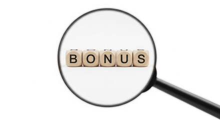 Magnifying glass focuses on wooden cubes spelling "bonus", symbolizing reward, achievement, or financial gain, ideal for business or finance concepts