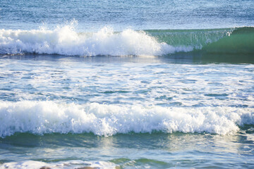 Waves breaking on the shore on the beach