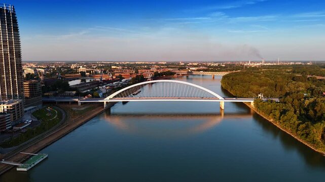 Descending above the calm waterscape of the Danube near the Appolo Bridge. Sunset scenery of Bratislava, Slovakia at backdrop.