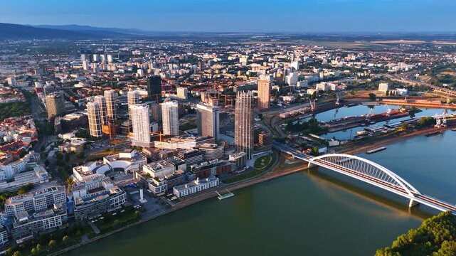 Modern cityscape of sunlit Bratislava, Slovakia. Footage above the Danube with the Appolo Bridge.