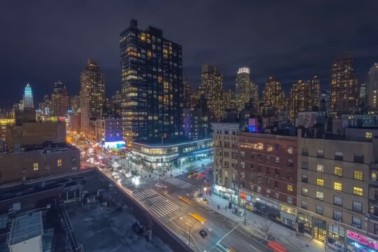 Timelapse view of a vibrant modern city at night with busy streets and towering skyscrapers, Aerial hyperlapse timelapse of modern, busy city street intersection and tall buildings at night