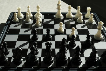 Close up shot hand of asian business person moving chess at office for training to defeat enemy king chess on white and black chess board for business challenge competition winner and loser concept.