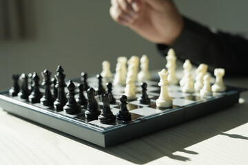Close up shot hand of asian business person moving chess at office for training to defeat enemy king chess on white and black chess board for business challenge competition winner and loser concept.