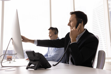 Businessman in suit engaged in phone call in modern office, engaged in business, professional...