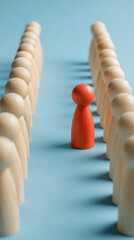 Single red wooden figure stands out from a line of pale wooden figures pawns