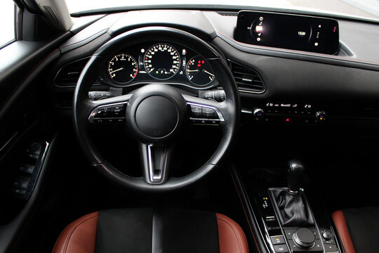View of the steering wheel and dashboard of the car from the driver's point of view. Modern interior and technology features inside a business class car
