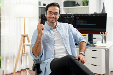 Profile's smart IT developer looking camera to pose wearing glasses against on software development...