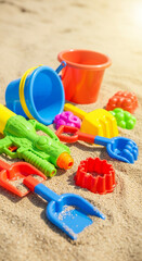 Water gun and beach toys on sandy ground