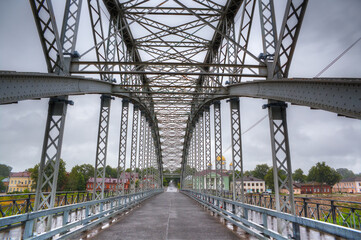 Naklejka premium Arched bridge made of metal structures in the city of Borovichi, Russia.