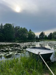 Serene Lakeside Scene with Rowboat and Lily Pads at Vilnius Botanical Garden, Lithuania – Summer...