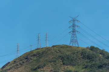 At the top of the mountain, the high-voltage tower rises between sky and rocks. A symbol of energy,...