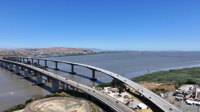 Martinez, CA, USA, 4k aerial video footage, climbing sidewards flying along Benicia-Martinez Railroad Bridge and Benicia&ndash;Martinez Bridge across Carquinez Strait with traffic running on roads
