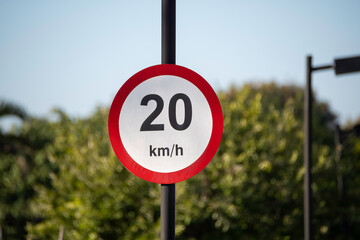 A 20 km/h speed limit sign alerts drivers to reduce their speed, ensuring safety in school, residential, or high-traffic areas.
