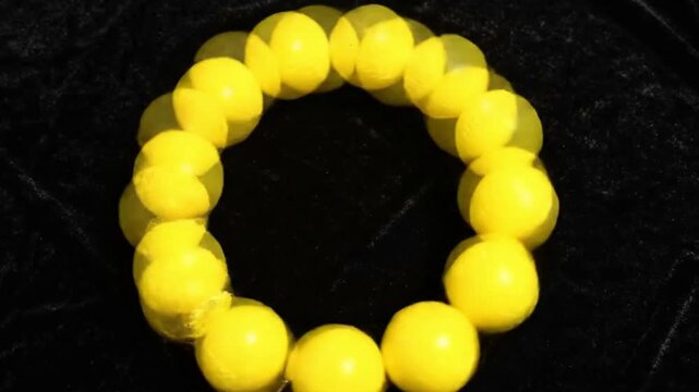 Looping Ring of Glowing Yellow Softballs on Velvet Background