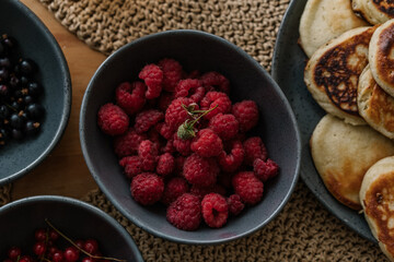 fresh raspberries in a bowl, aesthetic table setting with berries and pancakes