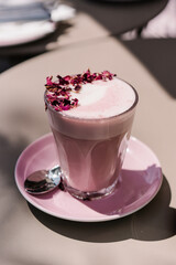 Rose Latte with teamed milk, rose syrup, beetroot powder and dried rose petals. Aesthetic pink preppy style	