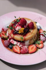 Midsummer Berry Pancakes with vanilla mascarpone, maple syrup and fruits. Pink plate, aesthetic desert, preppy style sweets	
