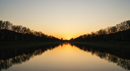 Obraz premium A serene, tranquil sunset over a still body of water, with trees lining the banks