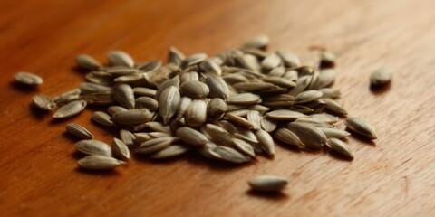 Obraz premium A pile of sunflower seeds resting on a warm, wooden surface, perfect for a healthy snack.