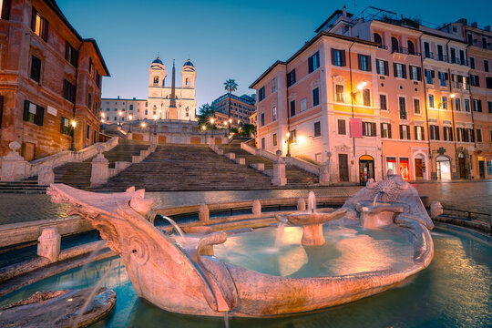 The famous Spanish Steps at dawn. View of the Barcaccia Fountain. Beautiful view of old buildings luminated by city lanthern. 