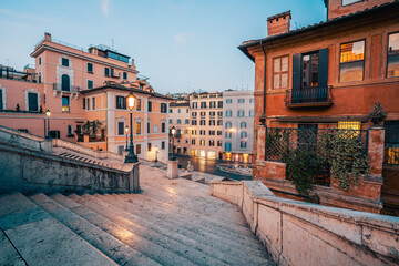 The famous Spanish Steps at dawn. View of the Barcaccia Fountain. Beautiful view of old buildings luminated by city lanthern. 