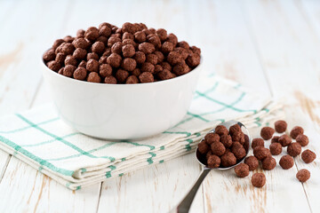 bowl of tasty chocolate corn balls on a light kitchen table, selective focus. Breakfast cereal.