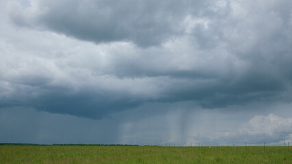 Dramatic Rain Clouds Hovering Over a Beautiful, Green Landscape Offering a Scenic View