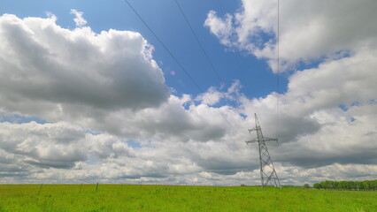 A detailed view of a high-voltage power tower standing tall with several cables hanging, an essential component in transmitting electricity across regions.