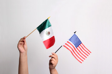 Hands holding flags of Mexico and the United States as a representation of international relations...