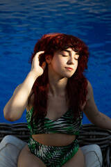 Relaxed young woman enjoying a day at the pool in summer