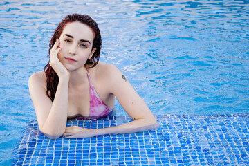 Relaxed young woman enjoying a day at the pool in summer