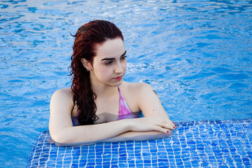 Relaxed young woman enjoying a day at the pool in summer