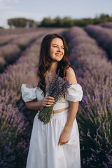 Young woman holding lavender bouquet in a lavender field