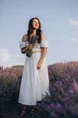 Young woman holding lavender bouquet in a lavender field