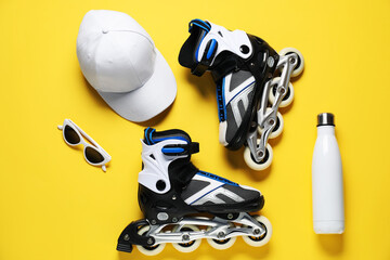 Flat lay composition with roller skates on yellow background