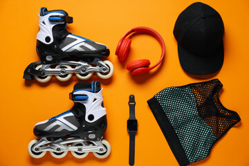 Flat lay composition with roller skates on orange background