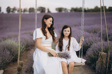 Mother and daughter swinging and enjoying a lavender field