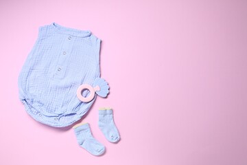 Baby clothes and accessory on pink background, flat lay. Space for text