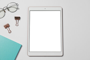 Tablet, stationery and glasses on white background, flat lay