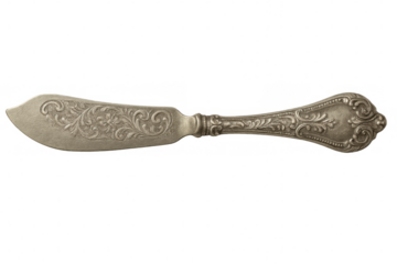 Vintage silver butter knife displaying delicate floral engraving on clean white surface