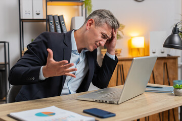 Tired Caucasian businessman feeling worried about financial problem, stress at home office...