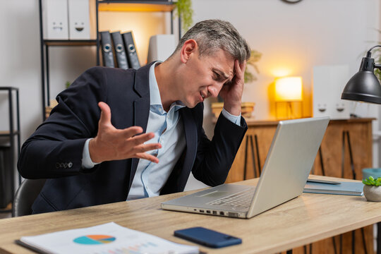 Tired Caucasian businessman feeling worried about financial problem, stress at home office workplace. Stylish freelancer man frustrated thinking of money debt, budget loss, bankruptcy. Overworking. - Powered by Adobe