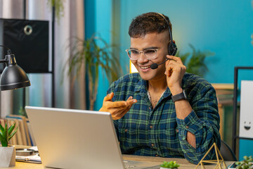 Indian business man wearing headset freelance worker call center or support service operator...