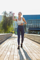 Athletic runner woman looks at smartwatch device fitness bracelet checking time, heart rate, pulse,...