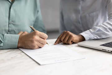 Close up view, man holding pen and signing lease or rental paper agreement, buying personal insurance coverage, committing to bank loan, credit line, or investment, accepting vendor or supplier terms