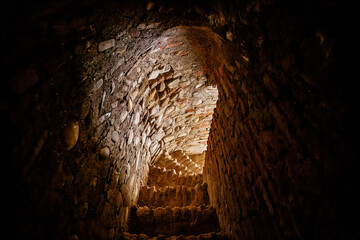 Stone narrow arched passage with spiral stairs