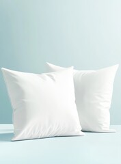 Two white square pillows on a light blue surface (1)